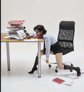 Woman crouching under an office desk in visible distress, symbolizing somatic hyper-responsivity and shutdown patterns in Emotional Outsourcing™