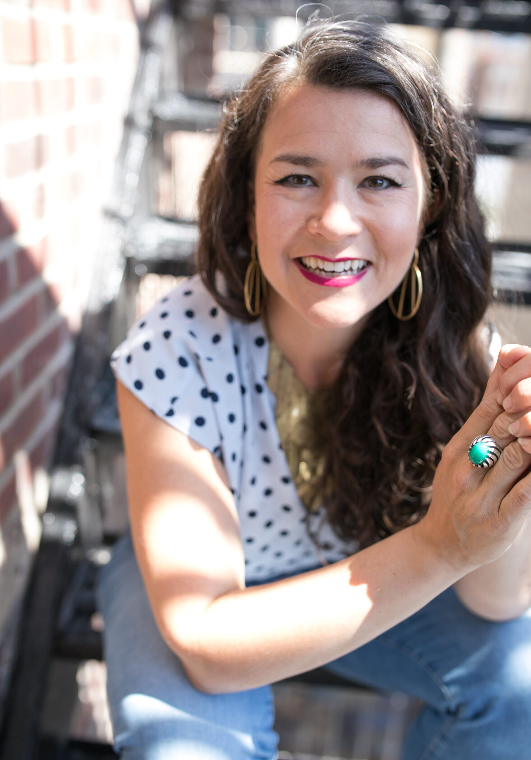 Victoria Albina on fire escape smiling right at camera